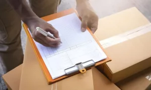 Zollbeamter prueft ein T1-Versandpapier im Versandverfahren an der Grenze