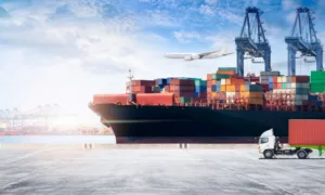 Frachtschiff mit Hafenkran und Lkw beim Umschlag einer DAP Sendung
